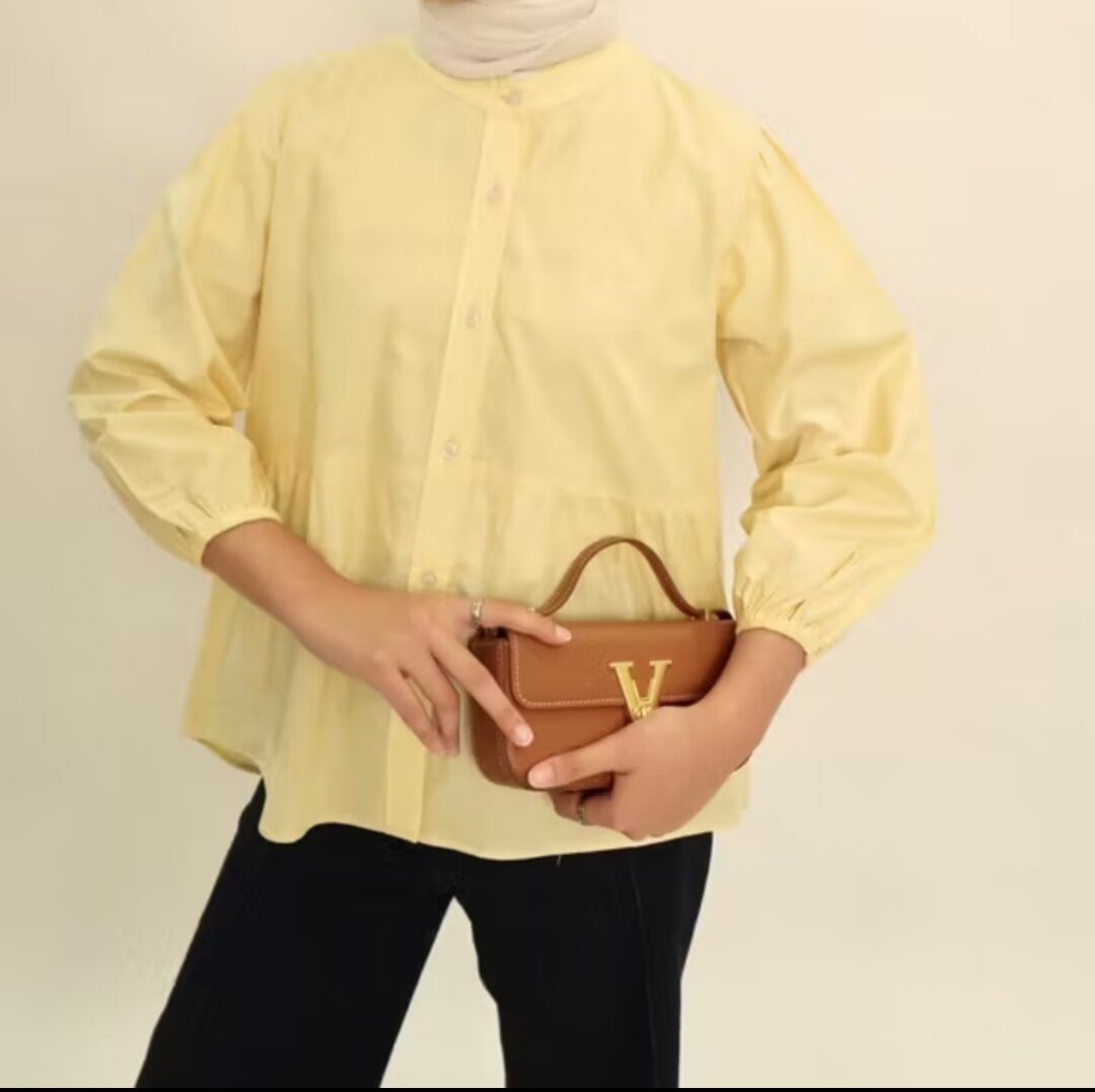 Blus wanita Kyren berwarna kuning muda dengan kerah bulat dan lengan tiga perempat. Desain simpel dan kekinian cocok untuk berbagai kesempatan.