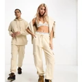 Calvin Klein Jeans unisex cargo trackies in beige - Exclusive to ASOS-Neutral